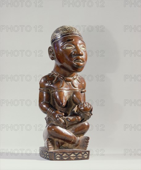 Mother and child carving (phemba) honouring female reproductive power an idealised image of womens role and by implication of the growth and wealth of the kingdom