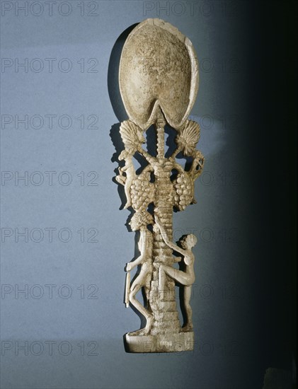 Unguent spoon in the form of a palm tree with a guard at its foot