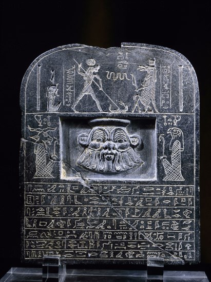 Reverse view of Horus stele, with relief mask of the god Bes, above a hieroglyphic text