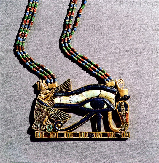 A pendant from the tomb of Tutankhamun in the form of a Wedjat eye, symbol of protection, flanked by the vulture goddess, Nekhbet and the snake goddess Wadjet, protectors of Upper & Lower Egypt