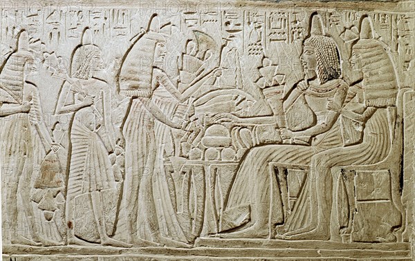 Stela relief with a couple seated before a table of food