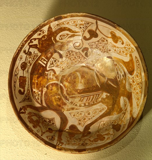 Lustreware plate with a design of a gazelle in lustre on an opaque white glaze