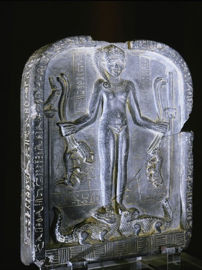 Stele with relief sculpture of Horus with the side lock of hair of youth, standing on two crocodiles