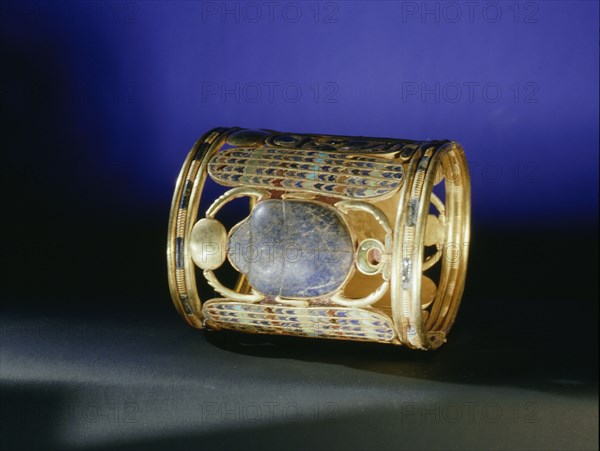 Gold bracelet from the tomb of Amenemope mounted with a lapis lazuli scarab bearing aloft the gold solar disc