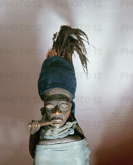 Figures such as this, with a mirror and bundle of medicines concealed in the cloth wrapper, were charged with power by a doctor (nganga) and used to protect, to promote wealth, or to attack enemies