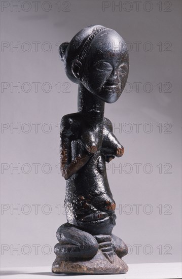 Wooden figure of Luba woman, served as a prestige possesion of a chief or king, illustrating the social and political importance of royal women in Luba society