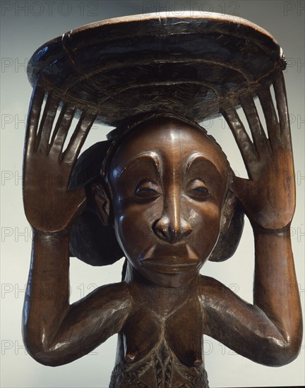 Chiefs stool supported by kneeling woman