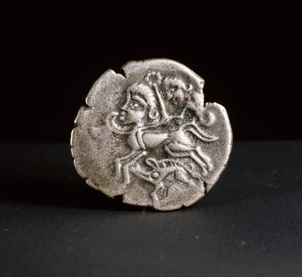 Low alloy coin showing a human headed horse guided by a person waving a torque