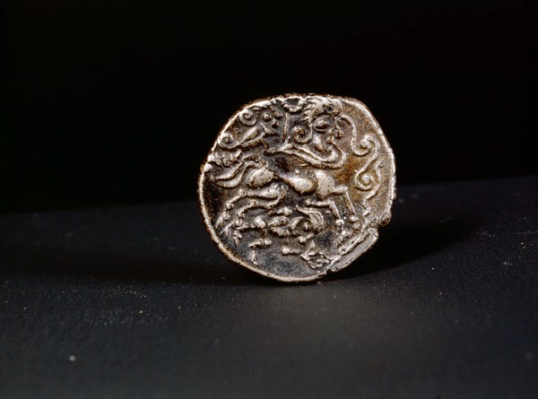 Low alloy coin showing a human headed horse guided by a person waving a torque