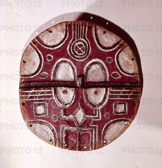 Circular mask used among the Tsaye in rituals of the Kidumu association, expressing social values through the abstract symbols taught to initiates