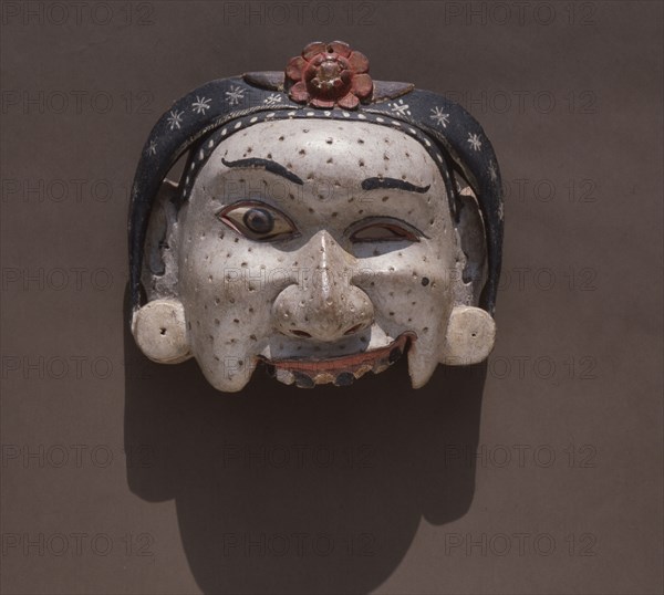 A half mask of a pock marked servant woman, used in wayang wong perform ances of the Hindu epics, especially the Ramayana
