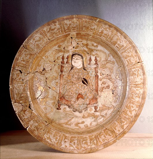 Painted and gilded plate with decoration of sitting man playing musical instrument