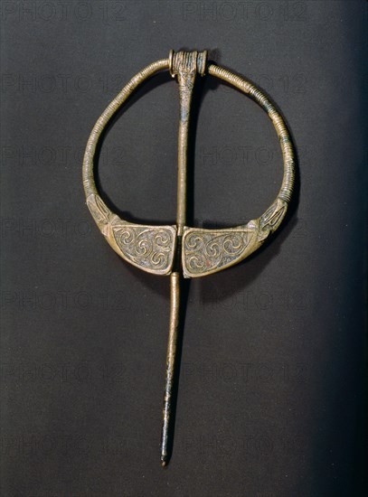 Enamelled brooch which owes its shape to Roman Britain but the flow of curves and counter curves is in the spirit of Celtic work of nearly a thousand years before