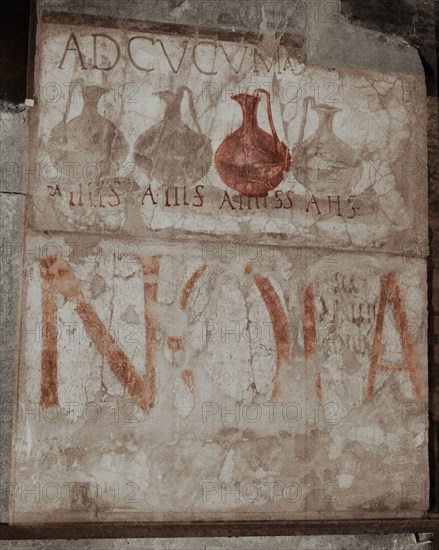 A wine shop sign in the main street, advising to come to the sign of the bowls (ad cucumas)