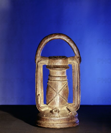 A wooden copy of a European oil lamp, probably intended to be covered with gold foil