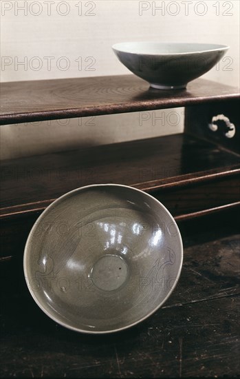 Two large bowls coated with a pale blue glaze and decorated with stylized phoenixes