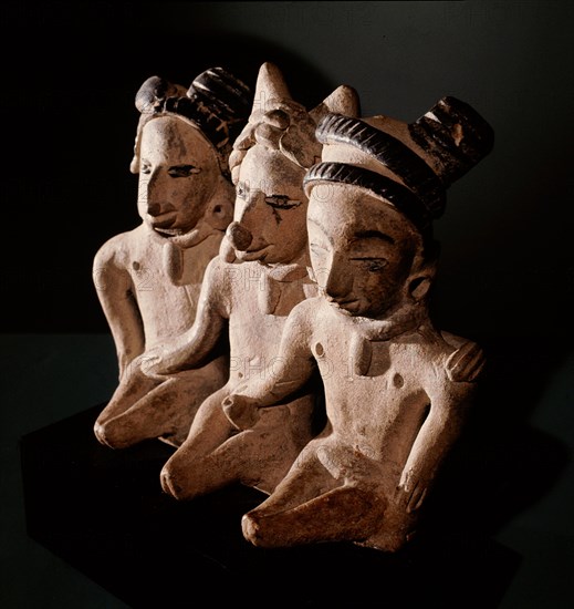 Three seated figures, a man flanked by two women