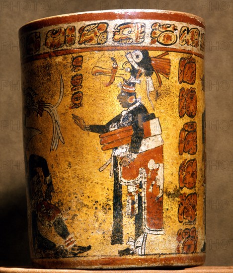 Cylindrical vessel decorated with date glyphs and a Mayan ball player wearing black body paint and heavy padding for the competition