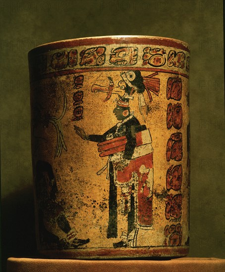 Cylindrical vessel decorated with date glyphs and a Mayan ball player wearing black body paint and heavy padding for the competition