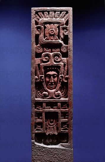 Stone column depicting Quetzalcoatl as Morning Star emerging from the jaws of a serpent   its forked tongue can be seen lolling from its lower jaw