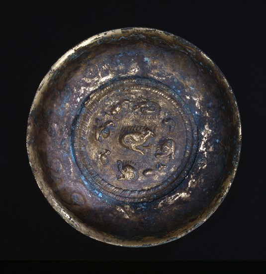 Inside view of gilt bronze bowl decorated with the heads of four mythical water beasts pursuing ducks and fish