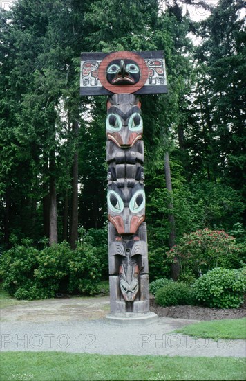 Totem pole with hawk or sunbird false box on the top