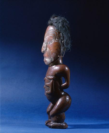 Carved wooden human figure with inlaid metal eyes and human hair