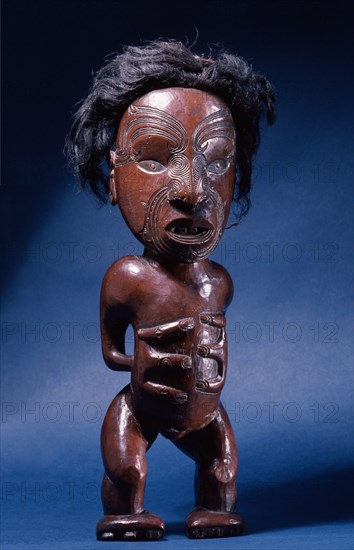 Carved wooden human figure with inlaid metal eyes and human hair