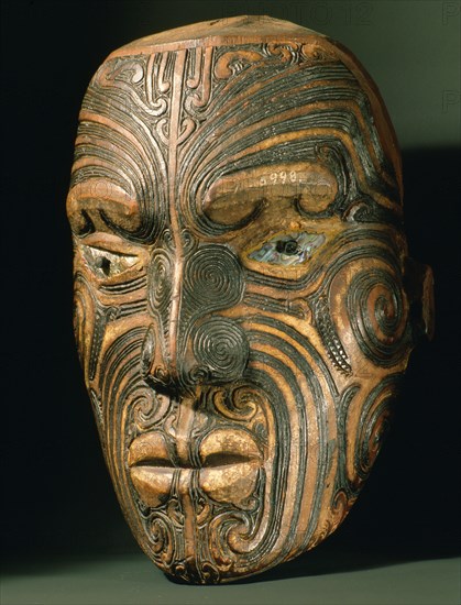 A carved wood Maori head with inlaid shell eyes