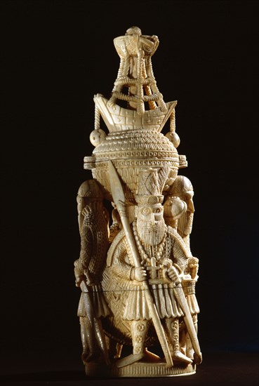 An ivory salt cellar around the base of which are figures of Portuguese noblemen