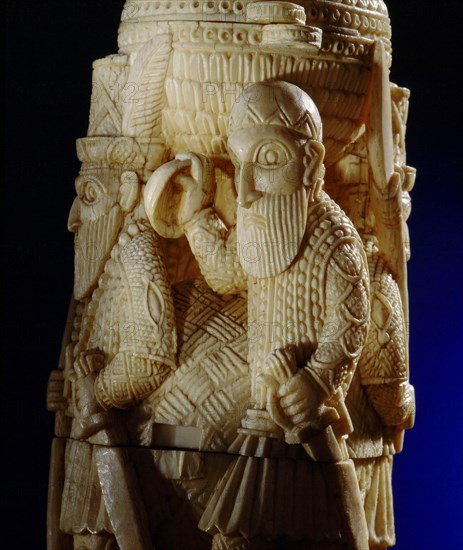 An ivory salt cellar around the base of which are figures of Portuguese noblemen