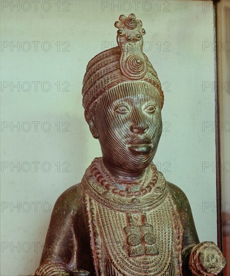 A portrait of an Oni wearing the traditional regalia; a crown, a beaded collar and heavy beads