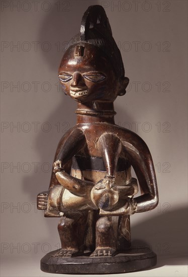 A wooden maternity figure, probably given as a thanksgiving offering to an orisha shrine following successful prayers for a child