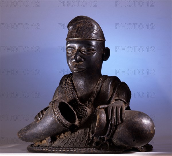 An unusual Yoruba carving of a man, probably a hunter carrying containers for medicines collected in the bush