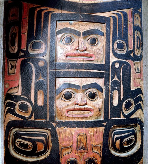 A carved and painted cedar board with a design showing ancestry and social position