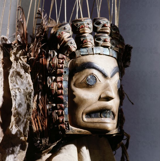 Chiefs headdress with humanoid face surrounded by a row of abalone shell and a double row of smaller faces