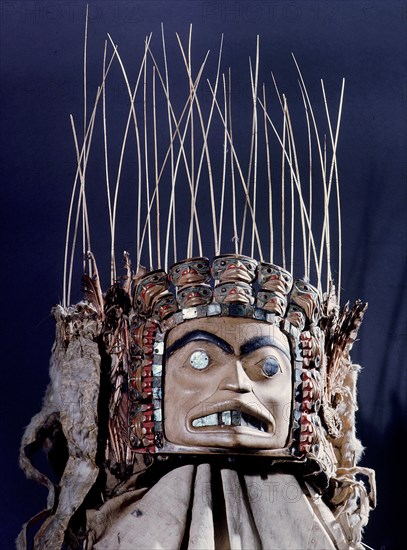 Chiefs headdress with humanoid face surrounded by a row of abalone shell and a double row of smaller faces