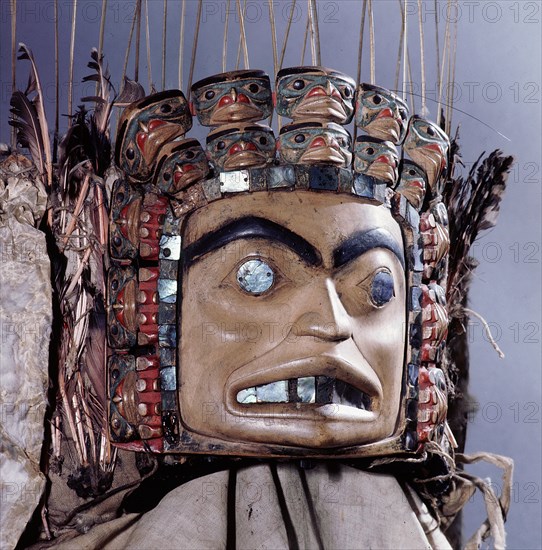 Chiefs headdress with humanoid face surrounded by a row of abalone shell and a double row of smaller faces