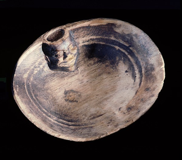 Flat wooden dish carved with a human head inside