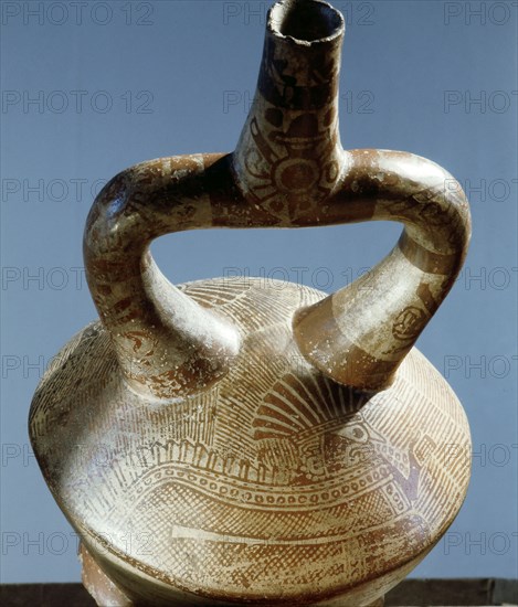 Late Mochica stirrup spouted jar showing an intricately painted supernatural figure with an elaborate feathered headdress and a serpentine body