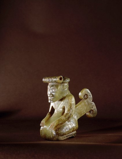 Carving of a kneeling man who wears patterned clothing