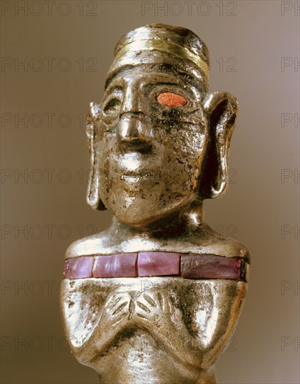 Male figurine cast in silver with unusual inlay of gold, stone and pink shell