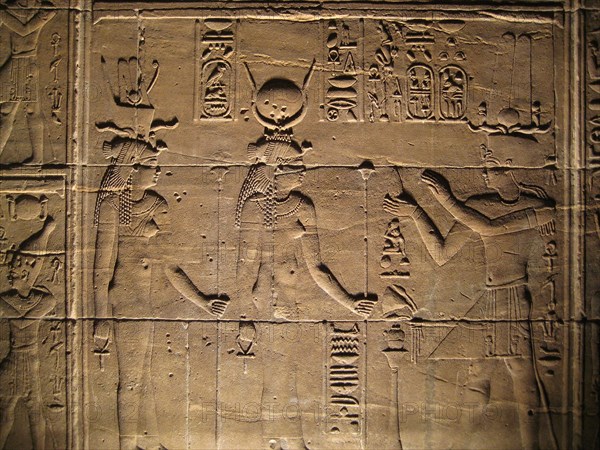 Relief depicting a pharaoh making offerings to the goddesses Isis and Hathor