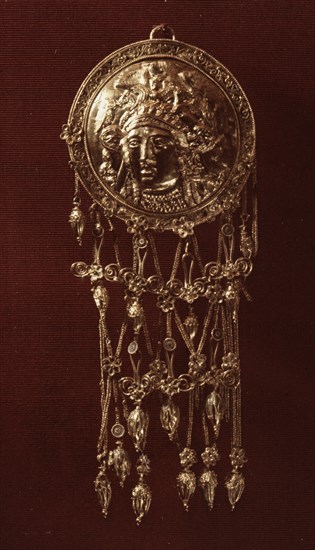 One of a pair of round forehead pendants with a relief design of Athena wearing a helmet richly ornamented with griffins from which hang elaborate crossed chains