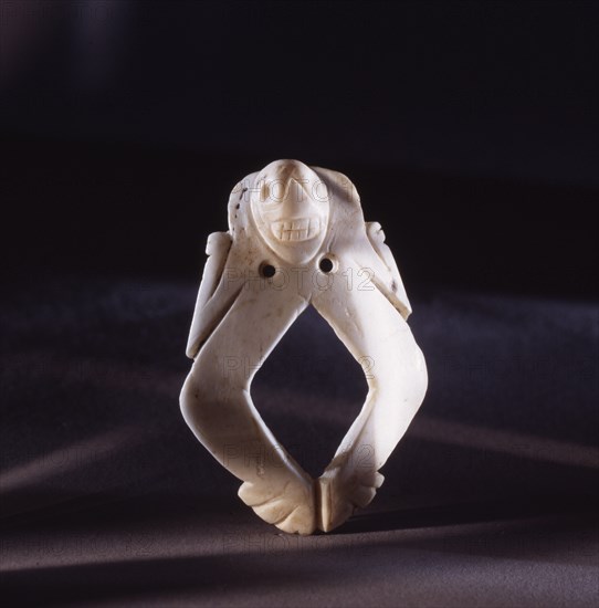 Shell amulet of a skeletal man