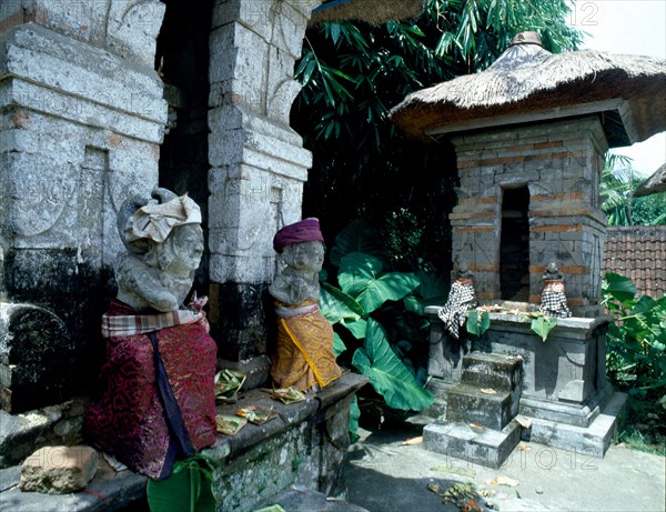 Divine gatekeepers at a small family temple dressed for a festival