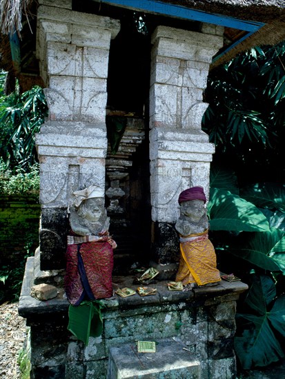 Divine gatekeepers at a small family temple dressed for a festival