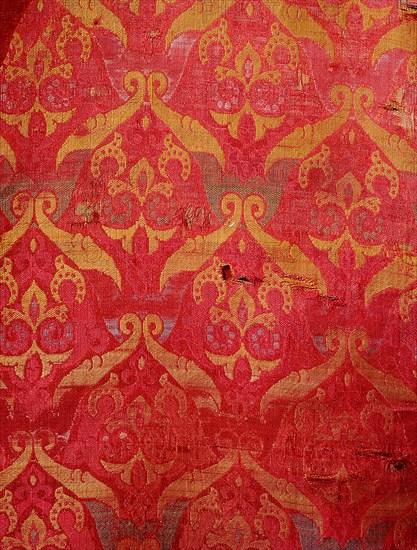 A detail of a red and gold silk weaving from Granada