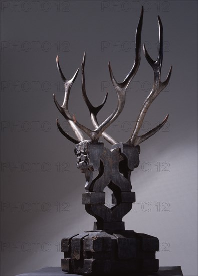 Wooden sculpture of mythical being with deer antlers