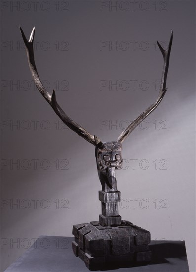 Wooden sculpture of mythical being with deer antlers